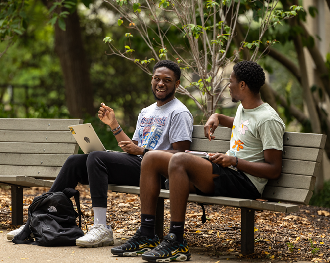 Students on bench talking.